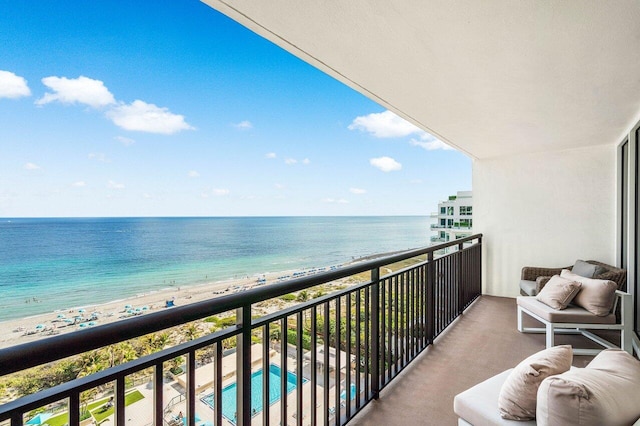 balcony featuring a water view and a beach view