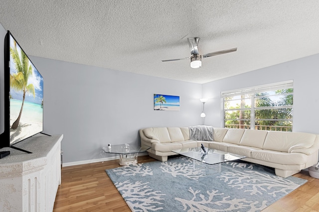 living room with hardwood / wood-style floors, a textured ceiling, and ceiling fan