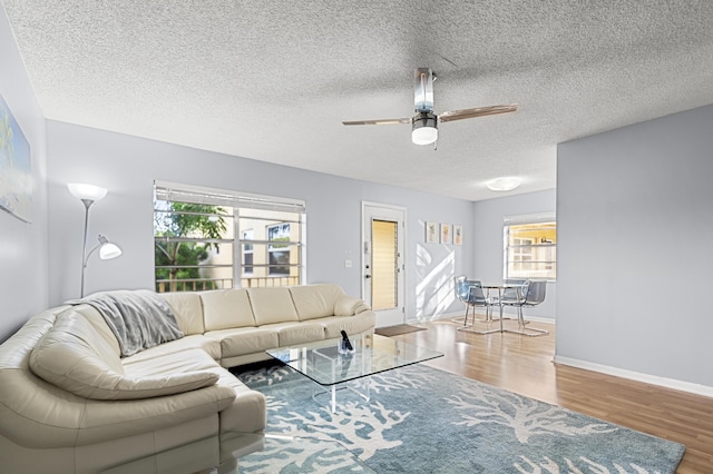 living room featuring hardwood / wood-style floors, a textured ceiling, a wealth of natural light, and ceiling fan