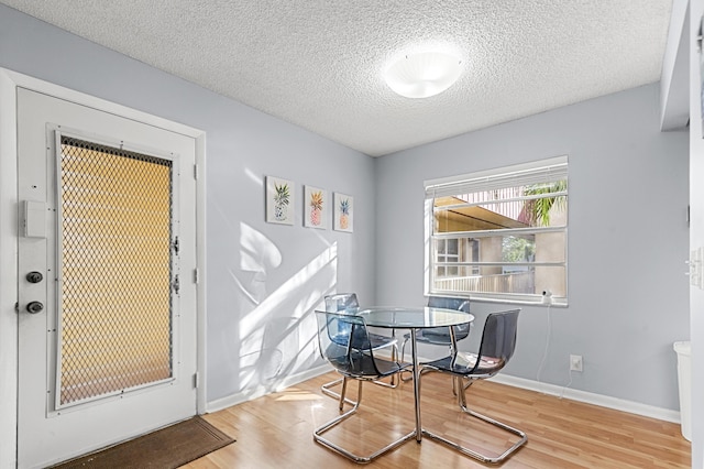 dining area featuring a textured ceiling and light wood-type flooring