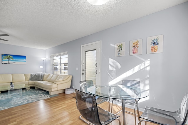 dining area featuring hardwood / wood-style floors, a textured ceiling, and ceiling fan