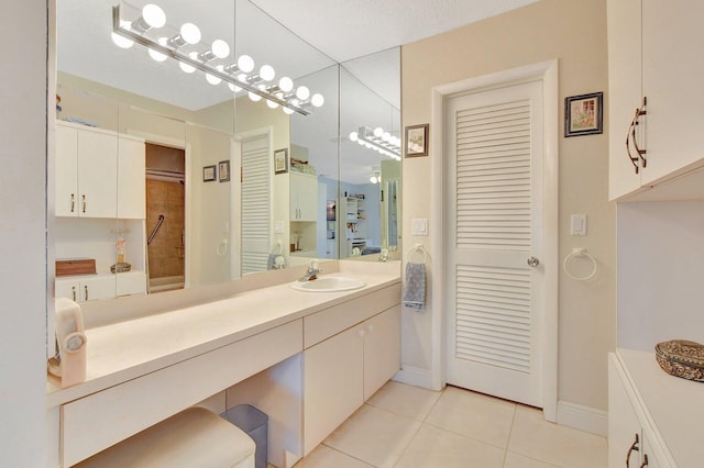 bathroom featuring tile patterned flooring, vanity, and a textured ceiling