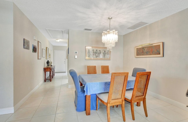 dining space featuring light tile patterned floors, a textured ceiling, and an inviting chandelier