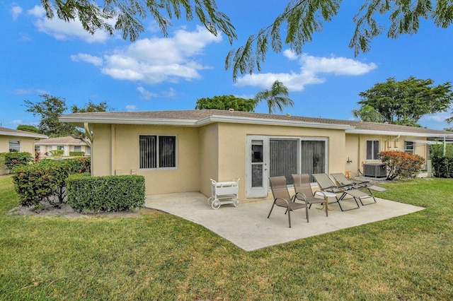 rear view of property with a lawn, a patio area, and central AC