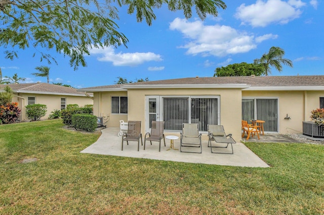 rear view of house featuring a lawn, cooling unit, and a patio