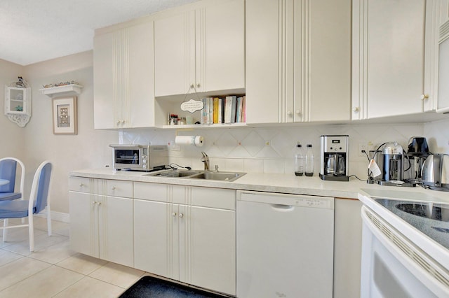 kitchen featuring white appliances, sink, decorative backsplash, light tile patterned floors, and white cabinetry