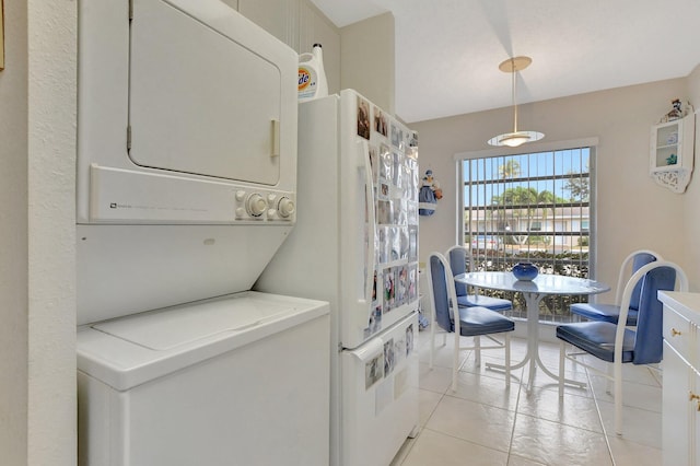 laundry area featuring light tile patterned floors and stacked washer and clothes dryer