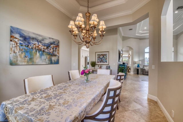 dining area with a chandelier, a raised ceiling, and ornamental molding