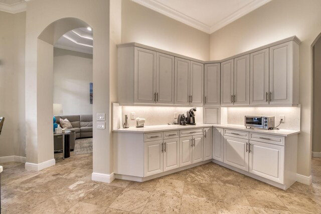 7541 Monte Verde Ln, West Palm Beach, FL 33412 - kitchen with ornamental molding, arched walkways, light countertops, baseboards, and decorative backsplash