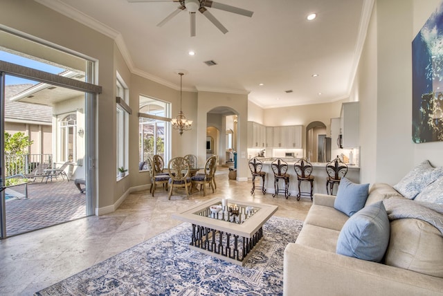 living room with ceiling fan with notable chandelier, crown molding, and a wealth of natural light