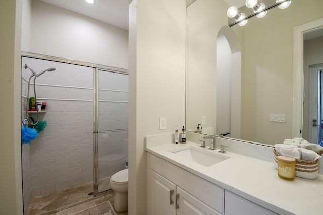 bathroom featuring tiled shower, vanity, and toilet