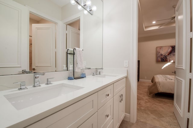 bathroom featuring a tray ceiling, ceiling fan, and vanity