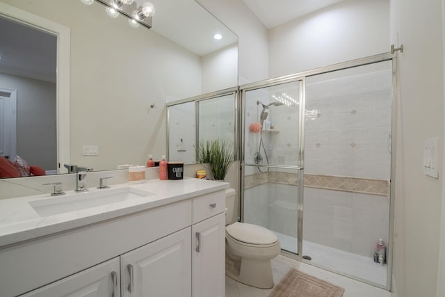 bathroom featuring tile patterned floors, vanity, a shower with shower door, and toilet