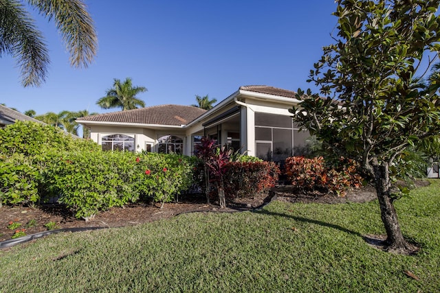 7541 Monte Verde Ln, West Palm Beach, FL 33412 - view of home's exterior featuring a tile roof, stucco siding, a lawn, and a sunroom