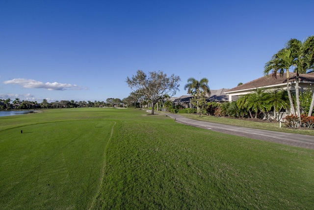 view of property's community with a lawn and a water view