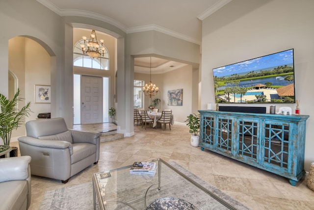 living room featuring ornamental molding, a high ceiling, and a notable chandelier