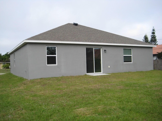 rear view of property with a lawn