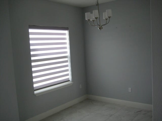 spare room with a notable chandelier