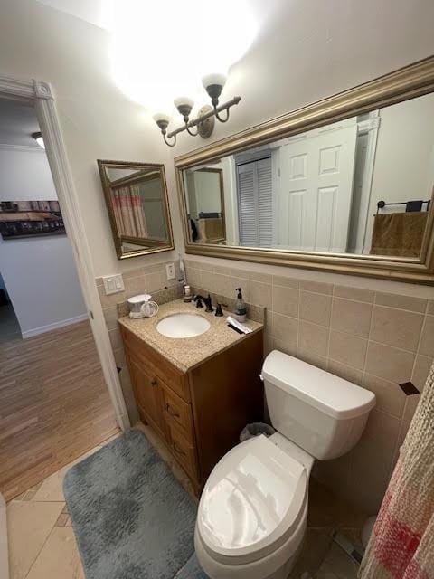 bathroom with tile patterned floors, vanity, tile walls, and toilet