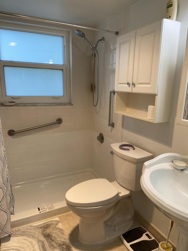 bathroom with curtained shower, sink, tile patterned flooring, and toilet