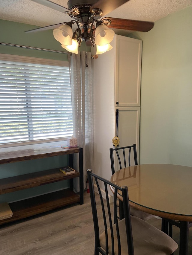 dining space with a textured ceiling, light hardwood / wood-style floors, and ceiling fan