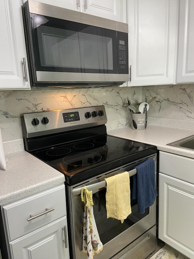 kitchen featuring white cabinetry, decorative backsplash, and appliances with stainless steel finishes