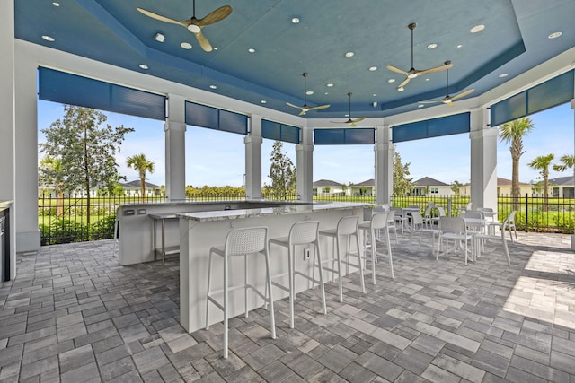 view of patio / terrace featuring ceiling fan and a bar