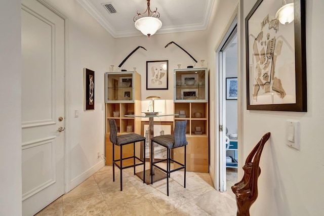 interior space with pendant lighting and ornamental molding