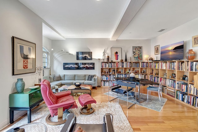 living room featuring beam ceiling and hardwood / wood-style flooring