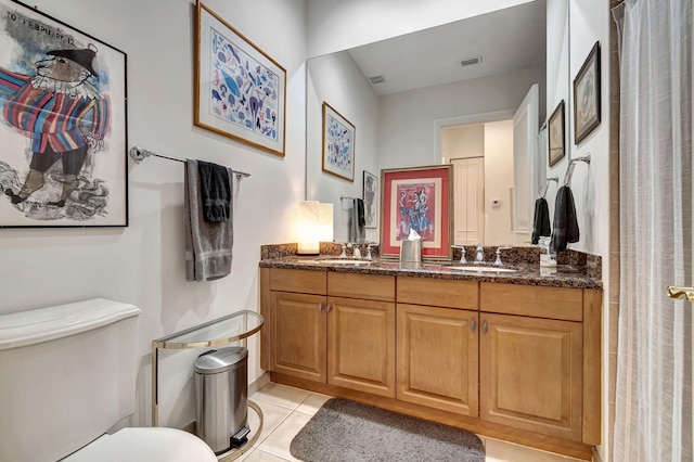 bathroom featuring tile patterned flooring, vanity, and toilet