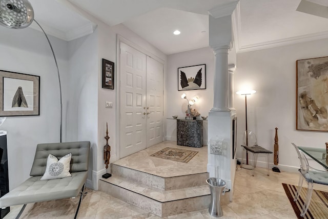 foyer entrance with ornate columns and crown molding