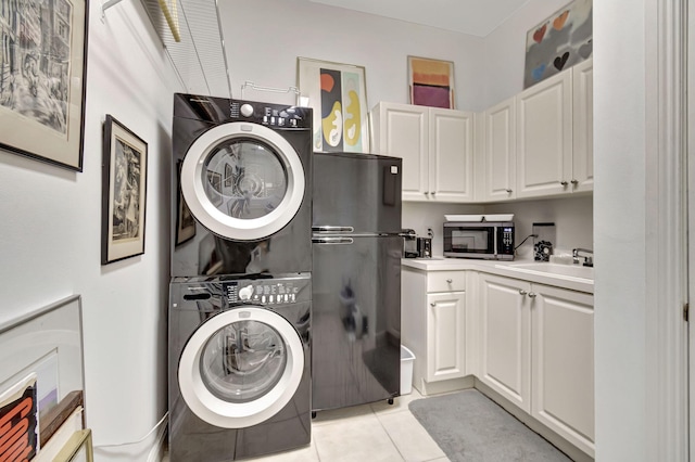 laundry room featuring stacked washer / dryer, sink, and light tile patterned floors