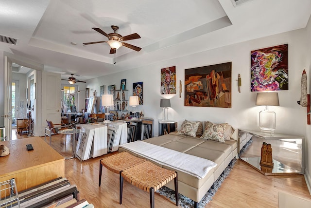 bedroom with a tray ceiling and light hardwood / wood-style floors