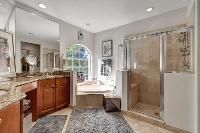 bathroom featuring plus walk in shower, vanity, and tile patterned flooring