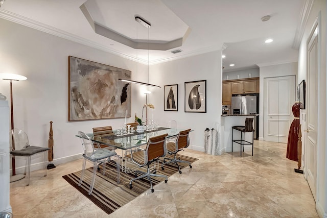 dining area with a raised ceiling and ornamental molding