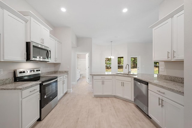 kitchen with light stone countertops, appliances with stainless steel finishes, sink, and white cabinets