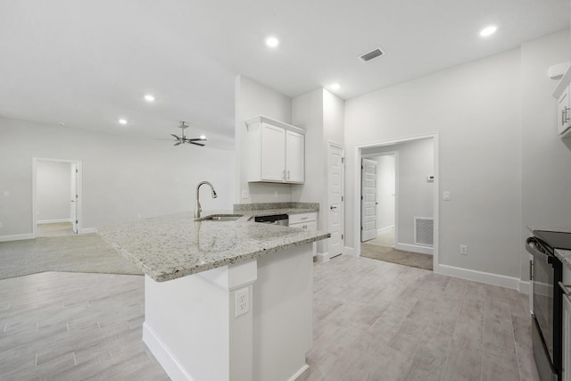 kitchen featuring sink, white cabinetry, light stone counters, black electric range, and light wood-type flooring