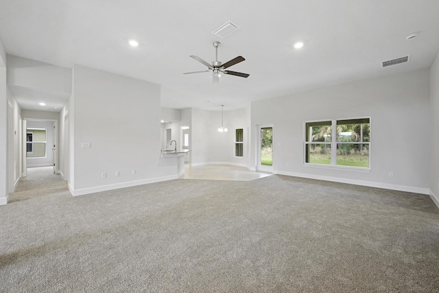 unfurnished living room featuring light colored carpet and ceiling fan