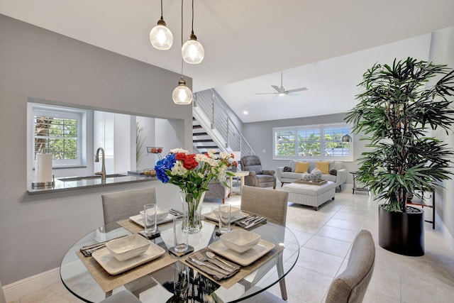 tiled dining area featuring ceiling fan and sink