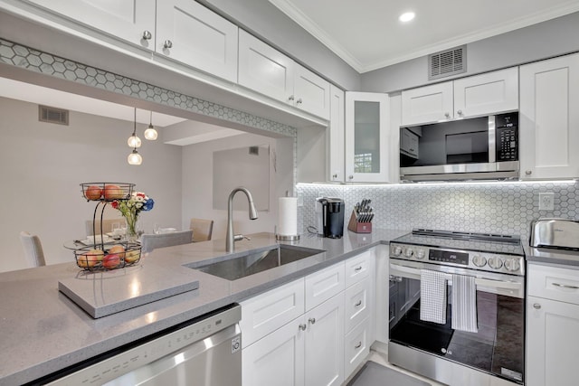 kitchen featuring white cabinets, backsplash, stainless steel appliances, and sink