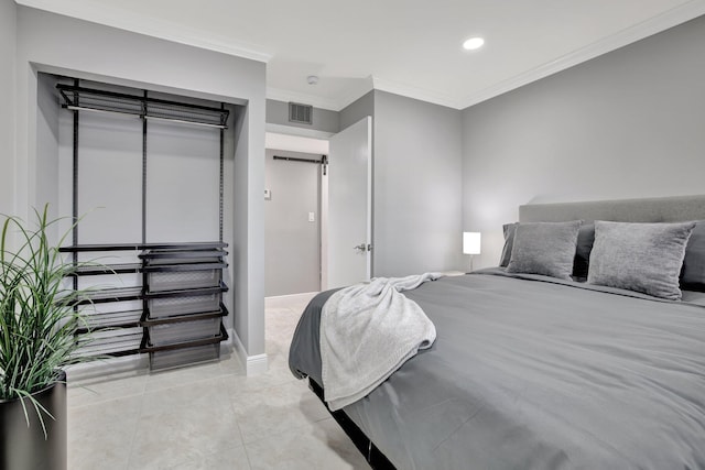 bedroom featuring light tile patterned floors, a closet, and ornamental molding