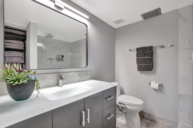 bathroom with a shower, vanity, and toilet