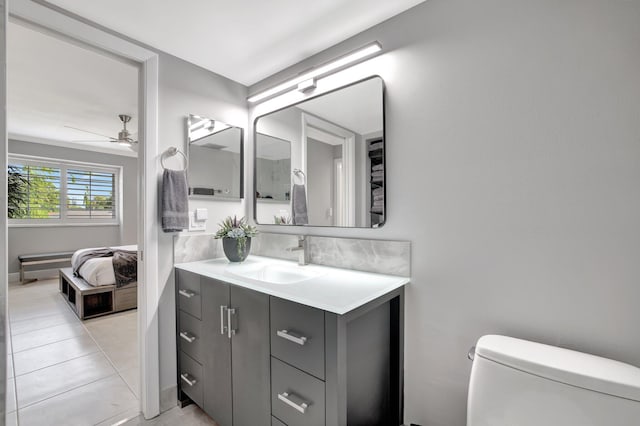 bathroom with tile patterned flooring, vanity, toilet, and ceiling fan