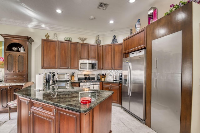 kitchen with backsplash, ornamental molding, stainless steel appliances, sink, and a kitchen island