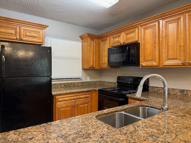 kitchen with a textured ceiling, sink, dark stone countertops, and black appliances