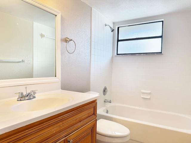 full bathroom featuring vanity, tiled shower / bath combo, a textured ceiling, and toilet