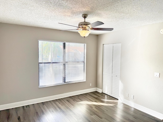 unfurnished bedroom featuring a textured ceiling, a closet, ceiling fan, and dark hardwood / wood-style floors