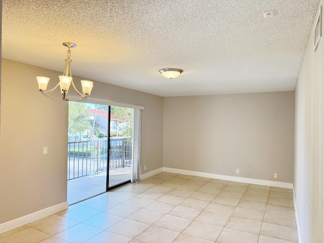 tiled empty room with a chandelier and a textured ceiling