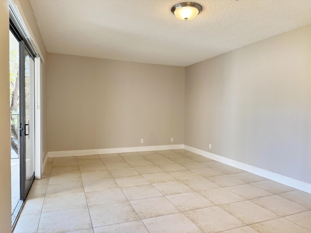 spare room featuring light tile patterned floors and a textured ceiling