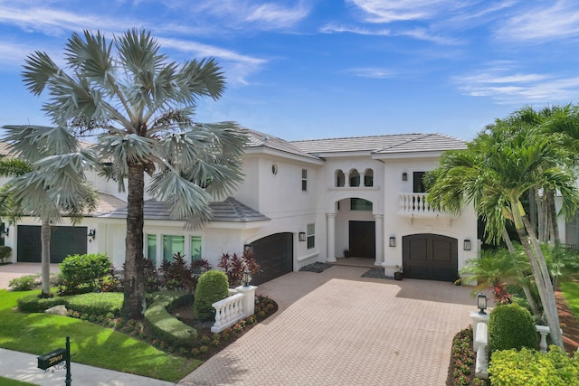 mediterranean / spanish-style house featuring a garage and a balcony